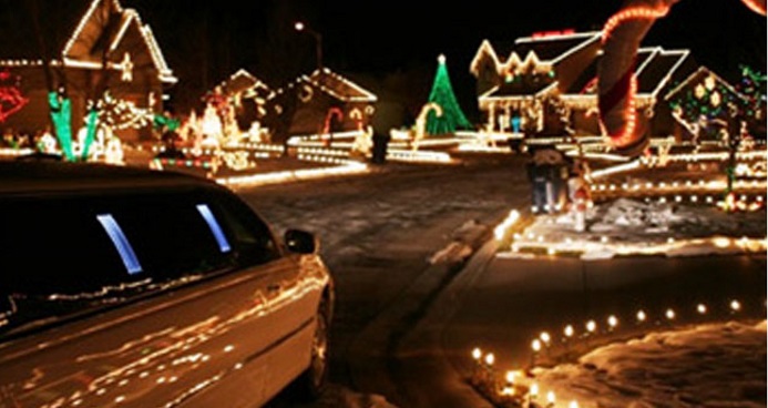 a limo driving and passing by decorated houses