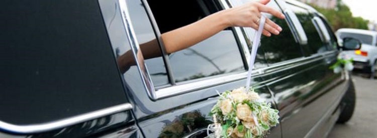 a hand stretching out of a limo window holding a bouquet